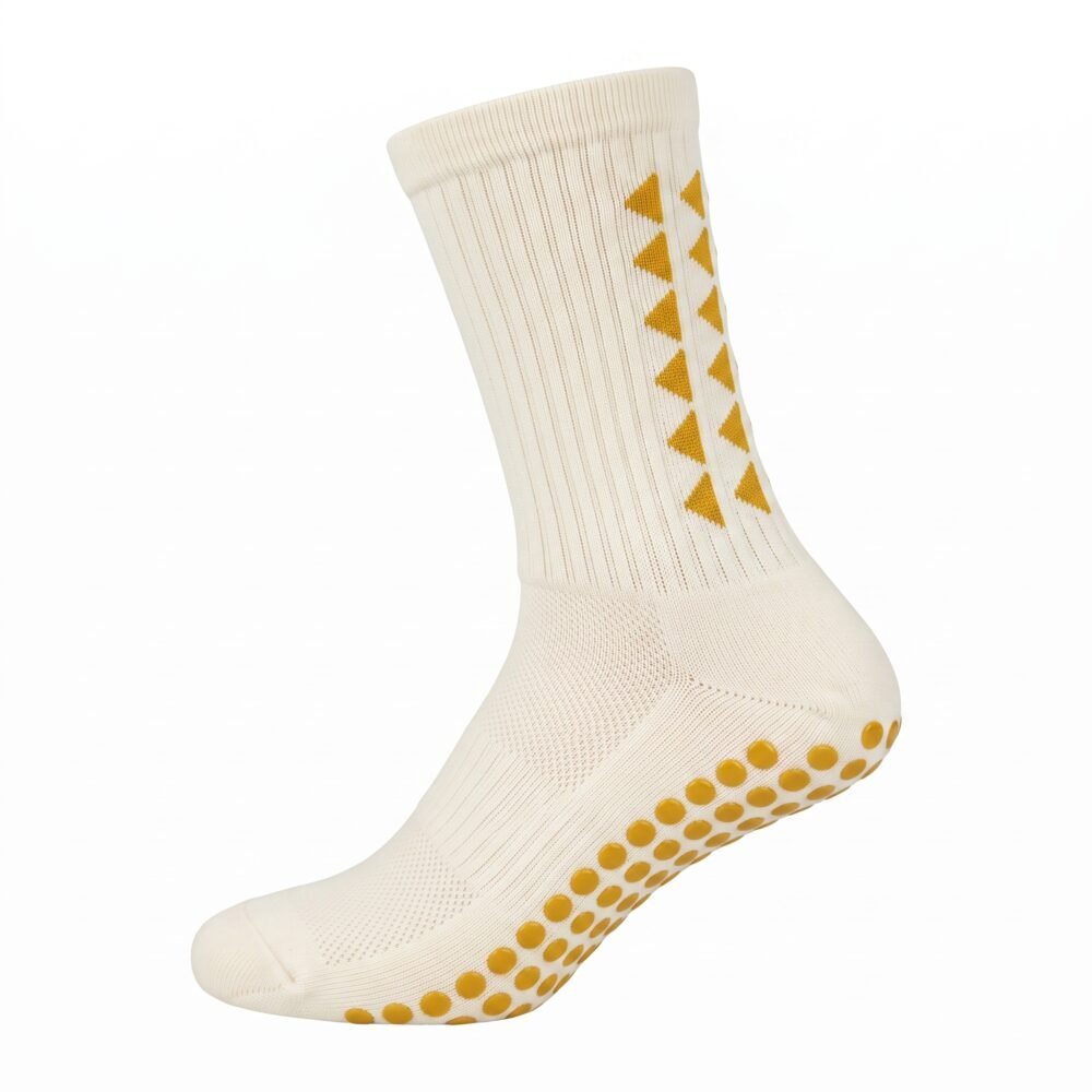 White Grip Socks with gold geometric accents and non-slip traction dots worn on a soccer field