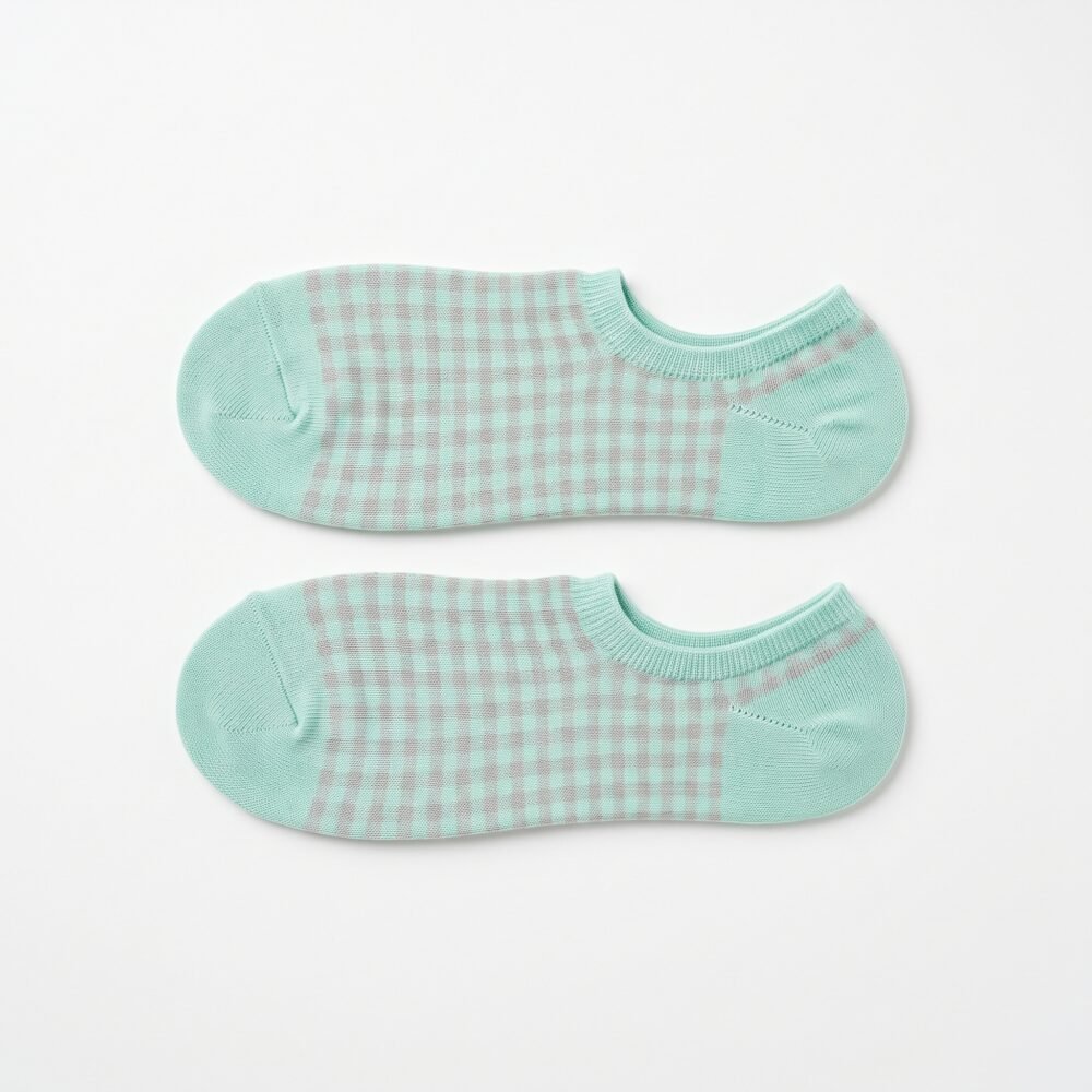 A pair of mint green no show socks with a grey gingham pattern laid flat against a white background.
