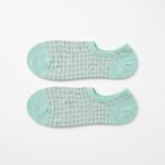A pair of mint green no show socks with a grey gingham pattern laid flat against a white background.