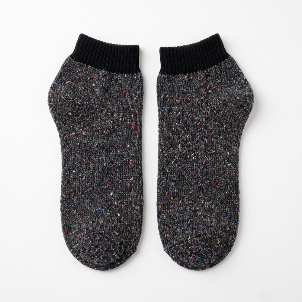 Black speckled ankle socks with ribbed cuffs displayed on a white background