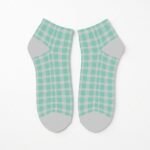 Pair of mint green and white checkerboard ankle socks with gray heel and toe panels on a white background