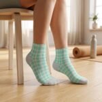 Pair of mint green and white checkerboard ankle socks with gray heel and toe panels on a white background