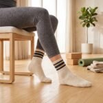 Pair of cream ankle socks with navy blue and gold striped cuffs