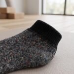 Black speckled ankle socks with ribbed cuffs displayed on a white background
