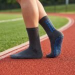 Black grip sock with blue non-slip traction dots across the sole