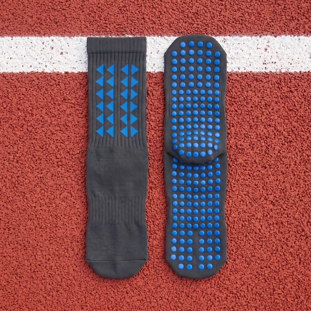 Black grip sock with blue non-slip traction dots across the sole
