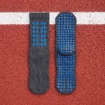 Black grip sock with blue non-slip traction dots across the sole