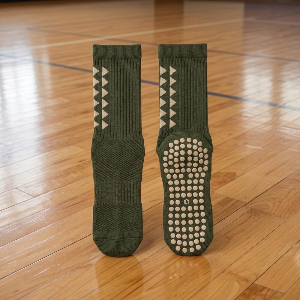 Olive green Grip Socks with cream geometric pattern and non-slip silicone dots worn during indoor athletic training