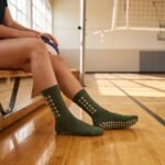 Olive green Grip Socks with cream geometric pattern and non-slip silicone dots worn during indoor athletic training