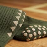 Olive green Grip Socks with cream geometric pattern and non-slip silicone dots worn during indoor athletic training