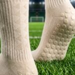 Cream Grip Socks with non-slip traction dots worn on artificial football field
