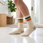 Lehvera merino wool hiking socks with cream base and colorful teal yellow and orange stripes