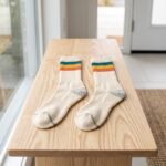 Lehvera merino wool hiking socks with cream base and colorful teal yellow and orange stripes