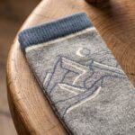 Merino wool compression socks in gray with navy accents and mountain pattern
