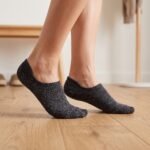 A pair of charcoal grey no show socks featuring multi-colored speckles, laid flat against a clean white background.