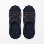 A pair of dark navy blue no show socks featuring a copper windowpane grid pattern across the top, laid flat against a clean white background.