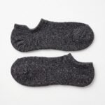 A pair of charcoal grey no show socks featuring multi-colored speckles, laid flat against a clean white background.