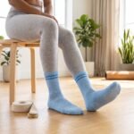 Light blue Pilates socks with white non-slip grip dots worn during an indoor workout