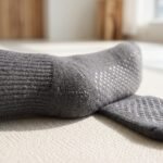 Charcoal gray Pilates socks with non-slip grip dots shown during a Pilates workout