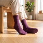 Plum purple pilates socks with non-slip grip soles worn during an indoor Pilates workout