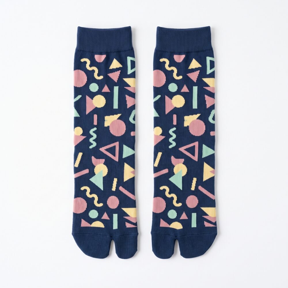 A person wearing navy blue crew-length Tabi socks featuring a colorful retro 80s geometric Memphis pattern, standing on a sunlit light wooden floor.