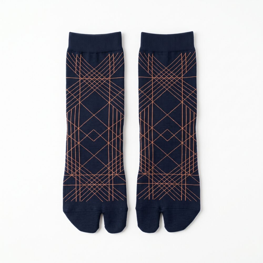 A person wearing navy blue crew-length Tabi socks featuring a copper geometric line pattern, standing on a light wood floor.