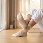 Woman wearing cream and tan checkered women’s crew grip socks with non-slip grip soles