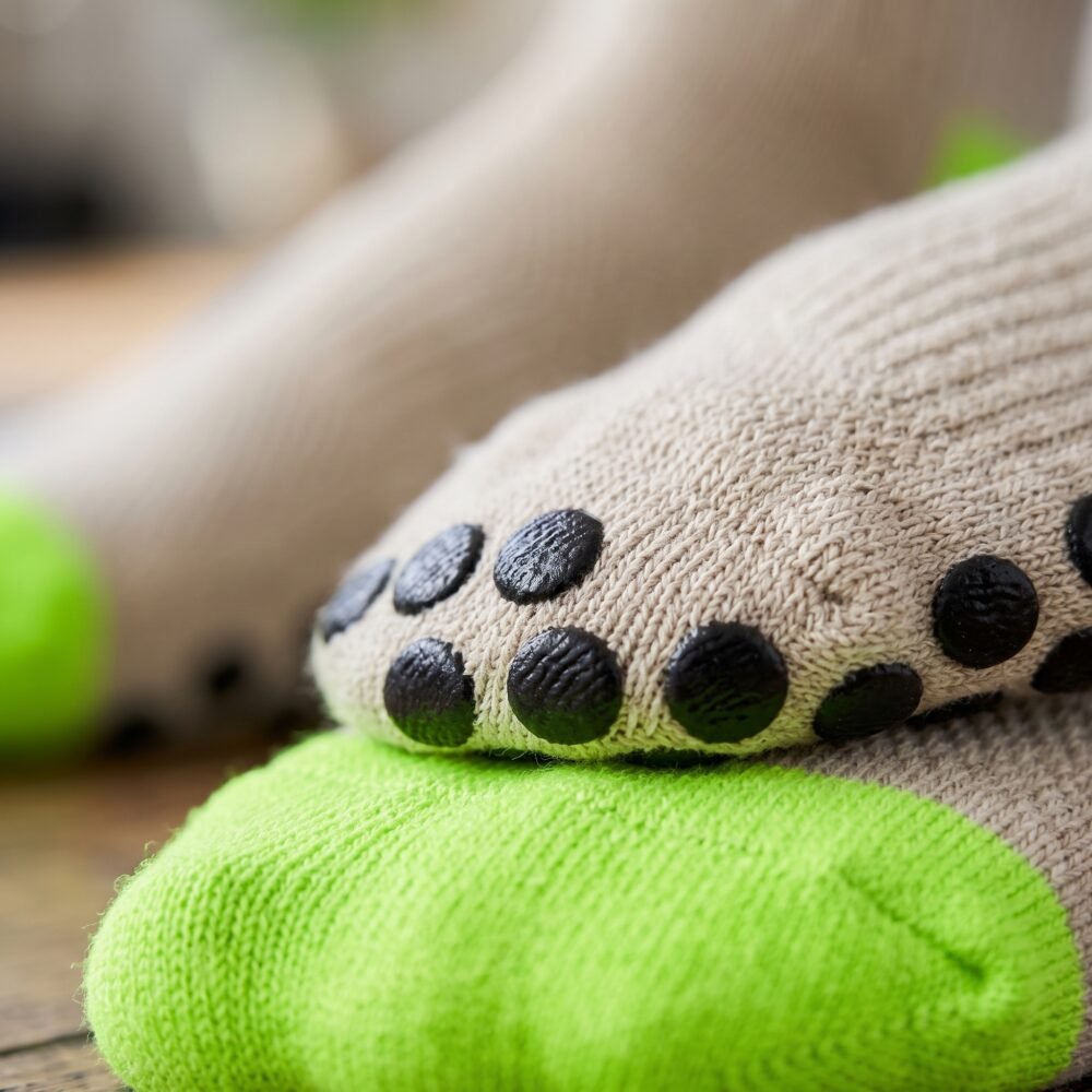 Women wearing beige Women’s Crew Grip Socks with black and lime green non-slip grip soles